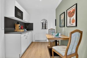 a kitchen with a table and a dining room at Design Mini Studio No 9, Küche, Parkplatz, Wifi by BALANCED in Holzkirchen
