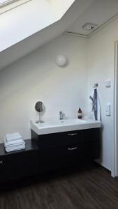 a bathroom with a sink and a white wall at Bolmen Bed - Vandrarhem in Ljungby