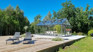 a gazebo with two chairs on a wooden deck at Bolmen Bed - Vandrarhem in Ljungby