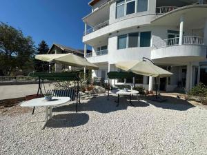 two tables with umbrellas in front of a building at Villa Nora in Albena