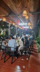 a group of people sitting at a table in a restaurant at Ali Garden Homestay Trang An Ninh Bình in Xuân Sơn