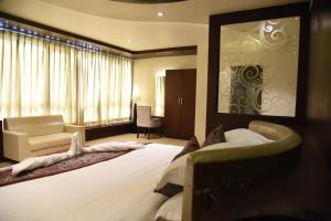 a hotel room with a large bed and a couch at Chola Nest in Ariyalūr