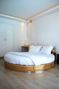 a bedroom with a large bed with white sheets at Chola Nest in Ariyalūr