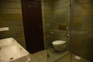 a bathroom with a toilet and a sink at Chola Nest in Ariyalūr