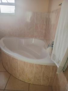 a bath tub in a bathroom with a sink at Buliso Homestay in Amsterdamhoek