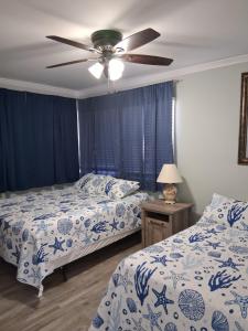a bedroom with two beds and a ceiling fan at Carolina Blue in North Myrtle Beach +38 photos