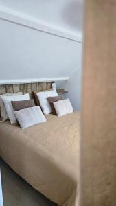 a bed with white pillows on it in a room at Casa del Castel in Dreux