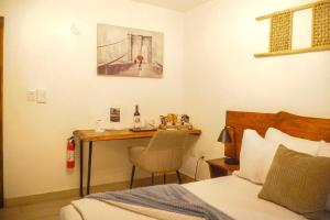 a bedroom with a bed and a desk with a bottle of wine at Distrito 27 in Santo Domingo
