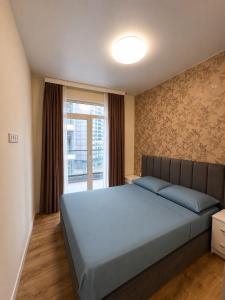 a bedroom with a large bed and a window at Bright large apartment in White Sails in Batumi +18 photos
