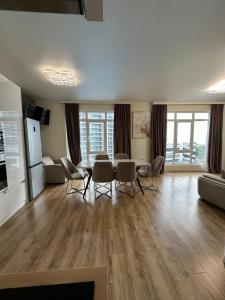 a living room with a table and chairs and a couch at Bright large apartment in White Sails in Batumi