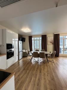 a kitchen and living room with a table and chairs at Bright large apartment in White Sails in Batumi