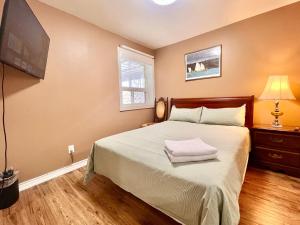 a bedroom with a large bed with a tv on the wall at Renovated Rooms 10-min to Finch Subway Near Yonge St in Toronto