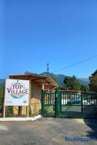a building with a top variance sign next to a gate at Top Village in Cogoleto