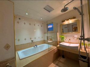 a large bathroom with a tub and a sink at Aika Homestay in Shah Alam
