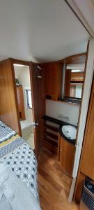 a small room with a bed and a sink at Gezellige luxe caravan met zwembad in zuid- Bourgogne in Anglure-sous-Dun