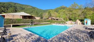 a swimming pool in a yard with mountains in the background at Chanteduc in Beaurières