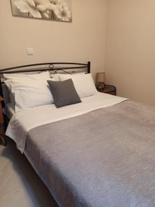 a bedroom with a large bed with white pillows at Magenta in Igoumenitsa +2 photos
