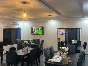 a dining room with tables and chairs and a tv at Chaniche Executive Lodge in Ndola