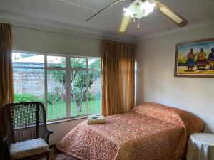 a bedroom with a bed and a large window at Highway Haven in Stilfontein