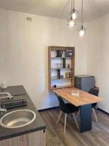 eine Küche mit Spüle und Arbeitsfläche mit Tisch in der Unterkunft Tra te e il Mare in Porto Torres