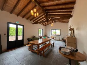 a living room with a wooden table and a dining room at Maison Elgenia in Saint-Martin-dʼArrossa