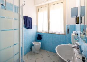 a blue tiled bathroom with a toilet and a sink at Hotel Oceano in Marina di Pietrasanta +51 photos