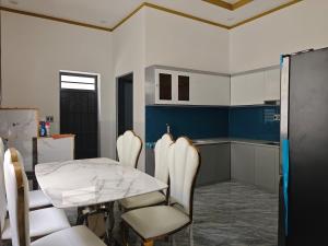 a dining room with a table and chairs and a kitchen at MAY homestay in Phú Khương