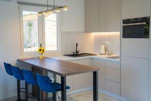a kitchen with a wooden table and blue chairs at Blue Velvet apartment in Lumbarda