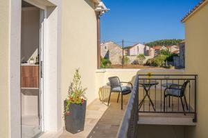 a balcony with chairs and a table on a balcony at Blue Velvet apartment in Lumbarda