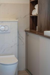 a bathroom with a white toilet and a sink at Blue Velvet apartment in Lumbarda +8 photos