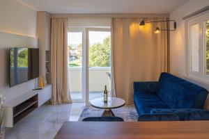 a living room with a blue couch and a table at Blue Velvet apartment in Lumbarda