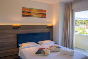 a bedroom with a bed with two pillows on it at Blue Velvet apartment in Lumbarda