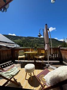 a patio with a table and chairs and an umbrella at Le Chalet d’Andrea in Vars