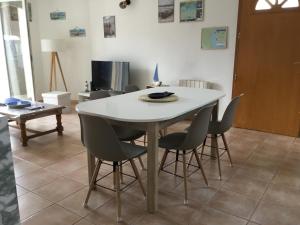 a dining room with a white table and chairs at Marseillan in Marseillan