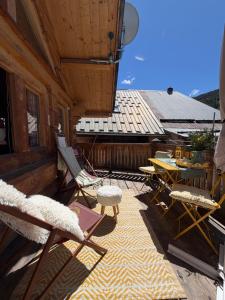 a patio with chairs and tables on a building at Le Chalet d’Andrea in Vars