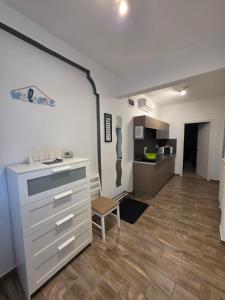 a kitchen with a dresser and a chair in a room at Smeraldo Home Fsz in Siófok