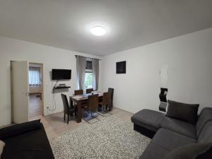 a living room with a couch and a table at Smeraldo Home Fsz in Siófok