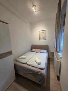 a small bedroom with a bed and a window at Smeraldo Home Fsz in Siófok