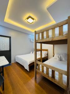 two bunk beds in a room with wooden floors at Aladdin's Guest House in Coron