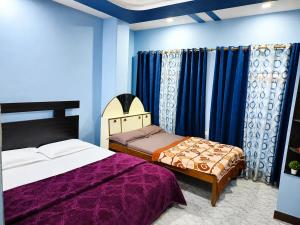a bedroom with two beds and blue walls at Hotel Rajmahal in Ajmer