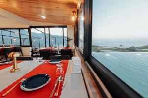 a dining room with a table and a view of the ocean at Seyr-i Mavi Bungalow in Mavikent