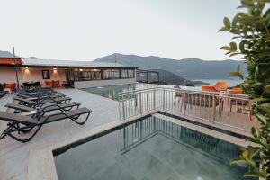 a house with a swimming pool with chairs and a building at Seyr-i Mavi Bungalow in Mavikent