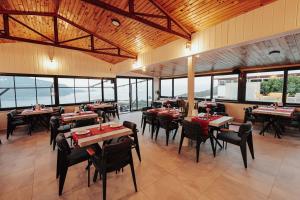 a dining room with tables and chairs and windows at Seyr-i Mavi Bungalow in Mavikent