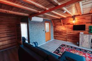a living room with a couch and a flat screen tv at Seyr-i Mavi Bungalow in Mavikent