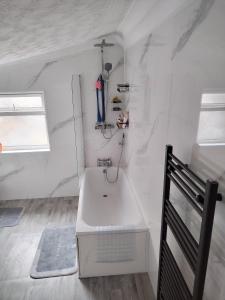 a white bathroom with a sink and a window at Murston Double Room in Kent