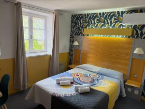 a bedroom with a bed with two towels on it at HOTEL GALIMAR in Lamalou-les-Bains
