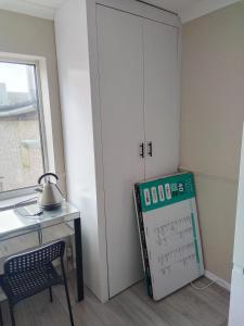 a room with a desk and a white cabinet at Murston Double Room in Kent