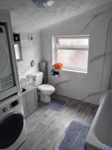 a bathroom with a toilet and a sink and a window at Murston Double Room in Kent