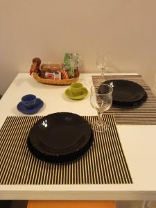 a table with two black plates and a wine glass at Magenta in Igoumenitsa