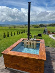 a hot tub in a wooden box with a stove at DANGUBA - Tiny Glamp House With Hot Tub by IGLENA in Kupres